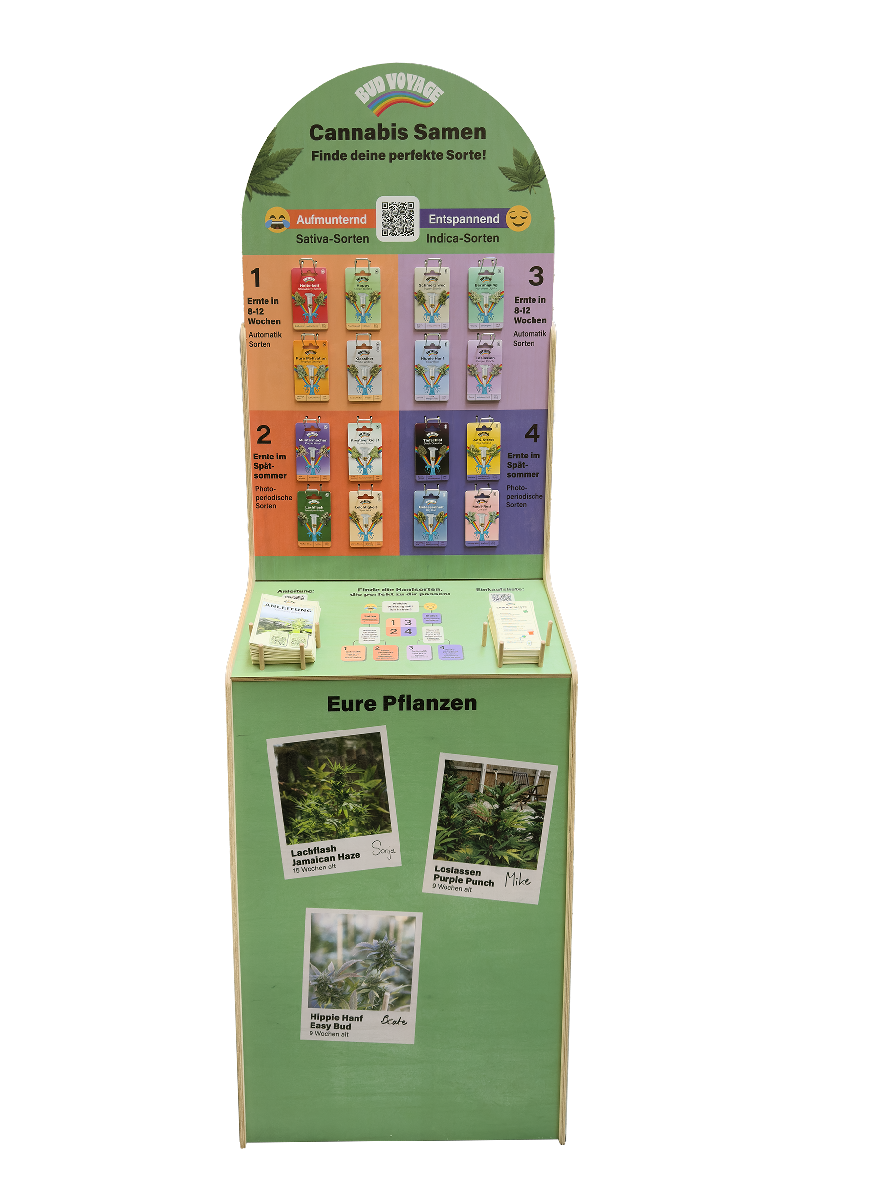 Stojan Bud Voyage zobrazuje odrůdy konopí, jako jsou Lachflash Jamaican Haze a Release Purple Punch, s barevnými obrázky a QR kódy na zeleném dřevěném pozadí.
