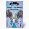 Grafický design Bud Voyage: feminizovaná semena Bubble Gum Sherb v průhledné zkumavce před duhovými a pastelovými vlnami s fialovými květenstvími a třemi semeny.
