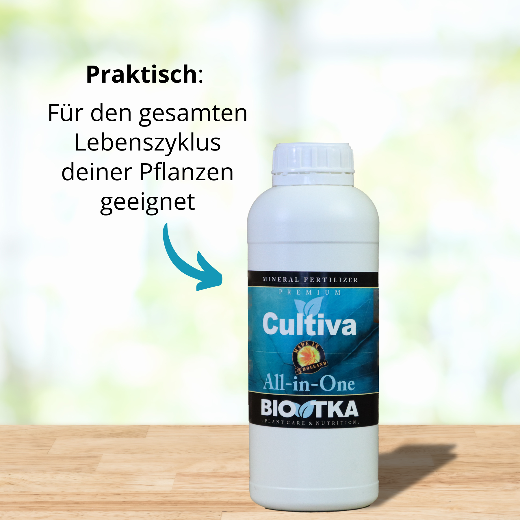 Snímek produktu BiotKa Cultiva All-in-One Premium Mineral Fertilizer, bílá láhev s modrou a zelenou etiketou, na světlém dřevěném povrchu na rozmazaném zeleném pozadí.
