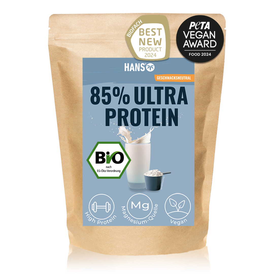 Obrázek produktu Hans 85% Ultra Protein Organic Powder, na kterém je zobrazena sklenice mléka, odměrka a loga pro certifikaci Organic, Peta Vegan Award a Best New Product 2024, s vysokým obsahem bílkovin a hořčíku a veganský.
