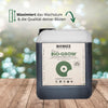 Biobizz Bio-Grow, ein dunkler, organischer Flüssigdünger in einer Plastikkanne auf einem Holztisch vor einem unscharfen grünen Hintergrund mit  Handcrafted-Siegel und World Wide Organics-Logo
