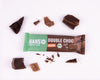 Snímek produktu Hans Double Choc Vegan Energy Bar s kousky hořké a mléčné čokolády na bílém pozadí s mátově zeleným obalem a měkkou, veganskou a bio etiketou.