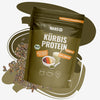 Produktfoto von Hans Kürbisprotein, einem gerösteten, veganen Proteinpulver mit hohem Magnesiumgehalt, das in einer braunen Verpackung mit grünen Akzenten gezeigt wird und neben einer Schüssel Müsli und einem Smoothie liegt,  eingebettet in eine Darstellung von Kürbiskernen

