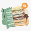 Produktová fotografie čtyř veganských energetických tyčinek Hanso Apfelstrudel Chocolate Chip Double Choc a Salted Peanut s bio certifikací a jemnou texturou v pastelových barvách.
