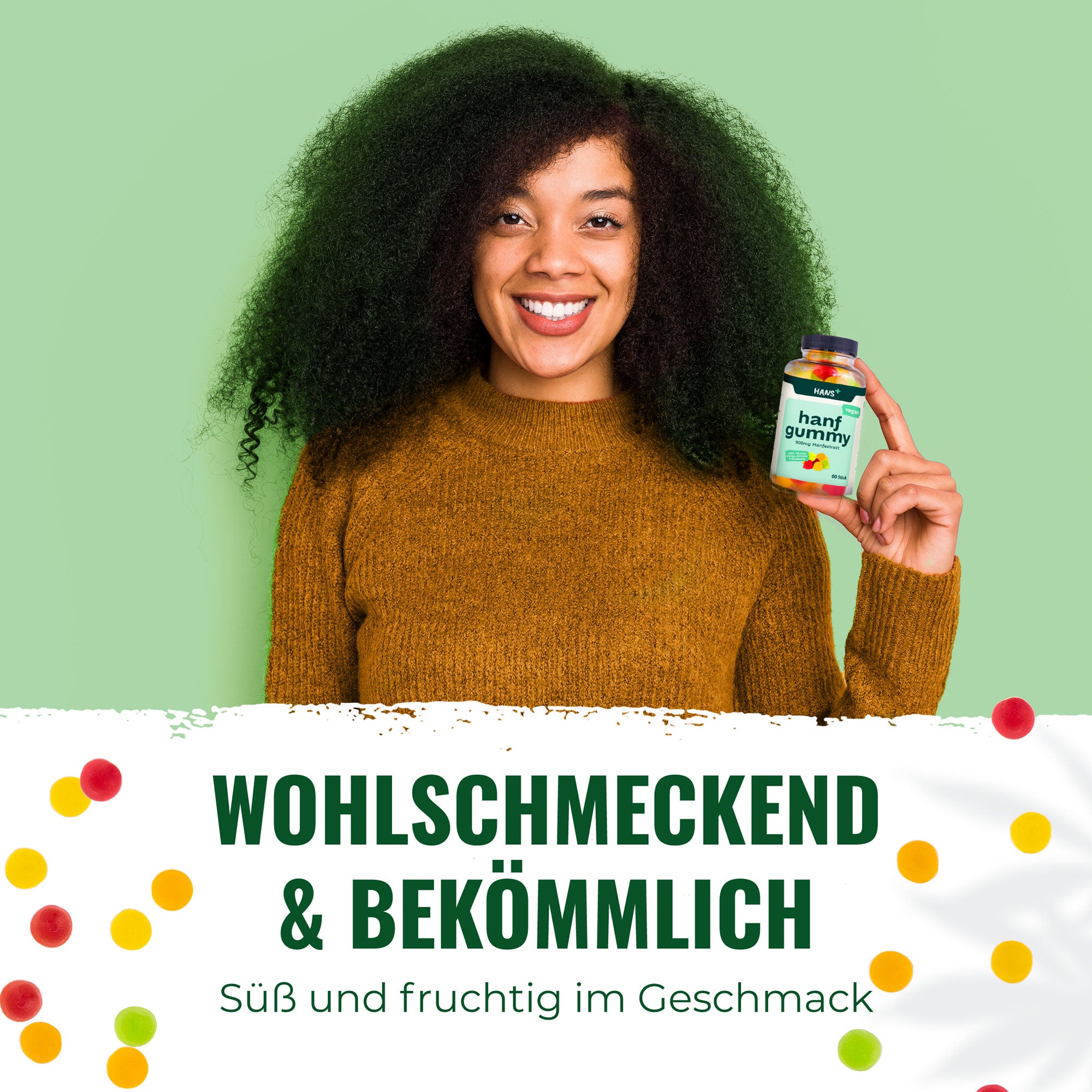 Product photography: A smiling woman with big, curly hair holds a bottle of hemp gummy bears with fruity, colorful bears in her hand against a light green background and wears a mustard yellow top.
