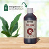 Product photo of Biobizz Top-Max, an organic flower stimulator in a dark brown bottle on a light wooden table against a blurred green background with a striking red logo, handmade since 1992 and of Dutch origin
