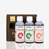 Biobizz product photography showing three bottles of Top Max, Bio Grow, and Bio Bloom plant nutrients in a brown box with red, green, and orange circular logos respectively.
