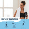 Photo of a woman in a gym, holding a protein shake, bright white towel, and black sports bra against a blurred background showing large bright windows