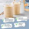 Food photography: Two creamy protein shakes in glasses with almond slivers, straws and a hint of shredded coconut on a light background
