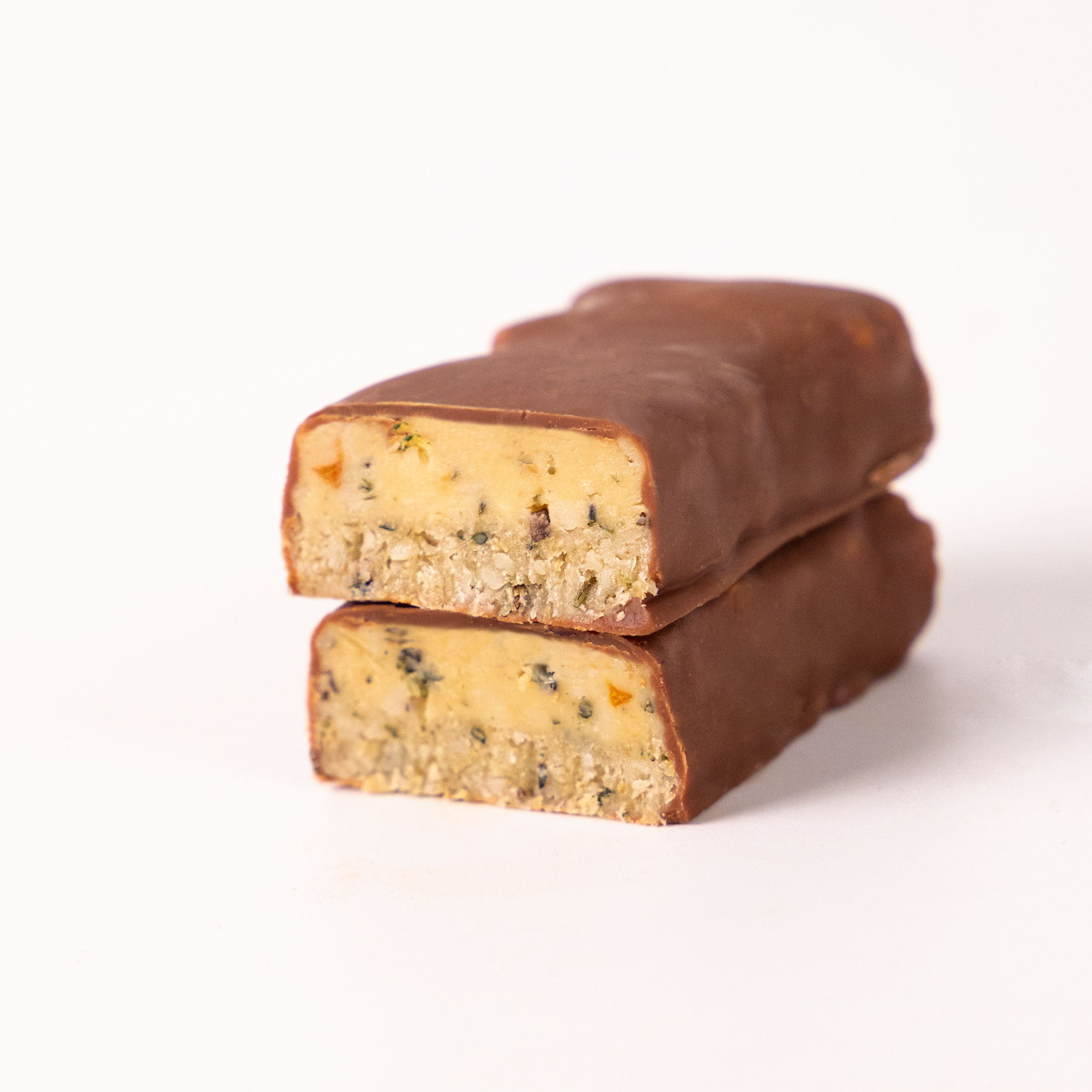Two chocolate bars with a light yellow filling, visible herbs and pieces of orange peel on a white background
